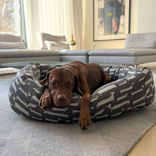 Load image into Gallery viewer, Dog relaxes in his Dashing Dogs Donut Dog Bed by Bowsers
