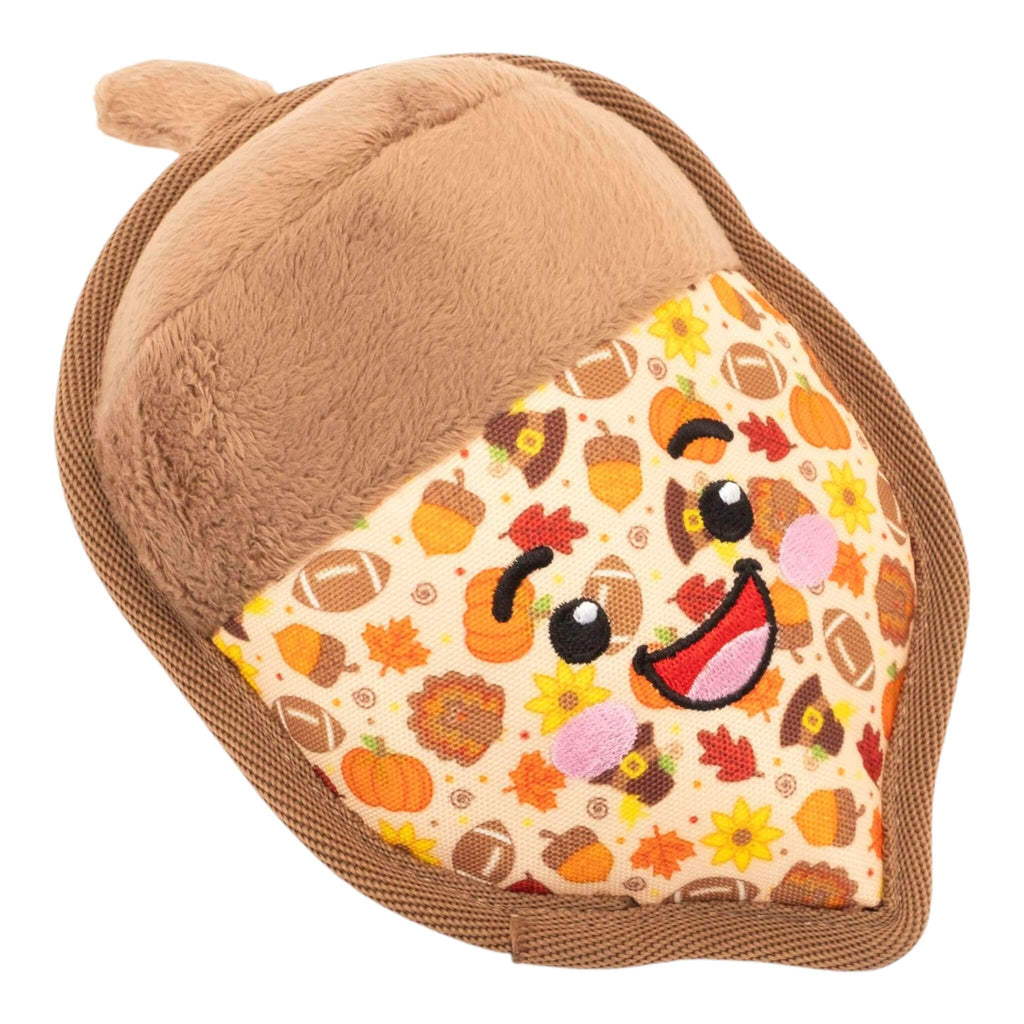 Plush acorn toy with a smiling face and autumn-themed pattern on a white background