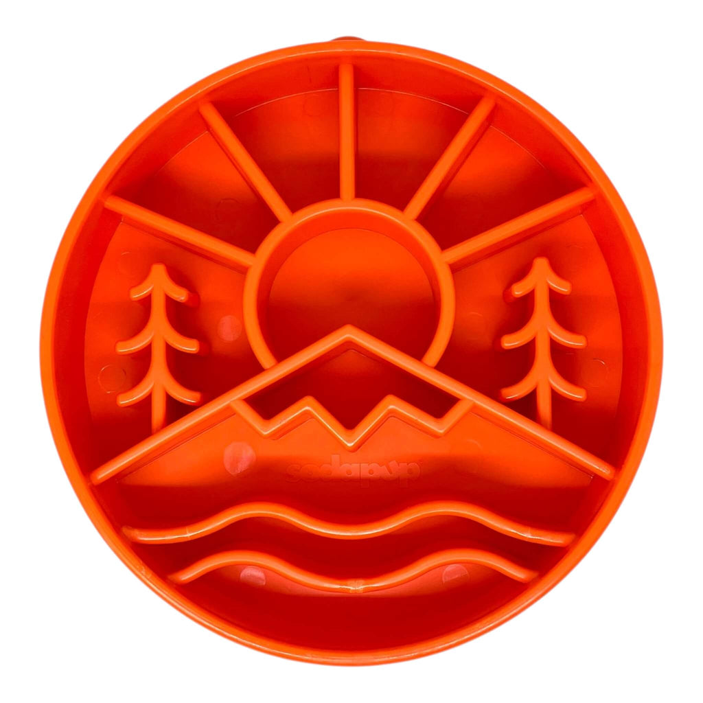 Orange slow feeder for dogs with nature-themed cutouts on a white background