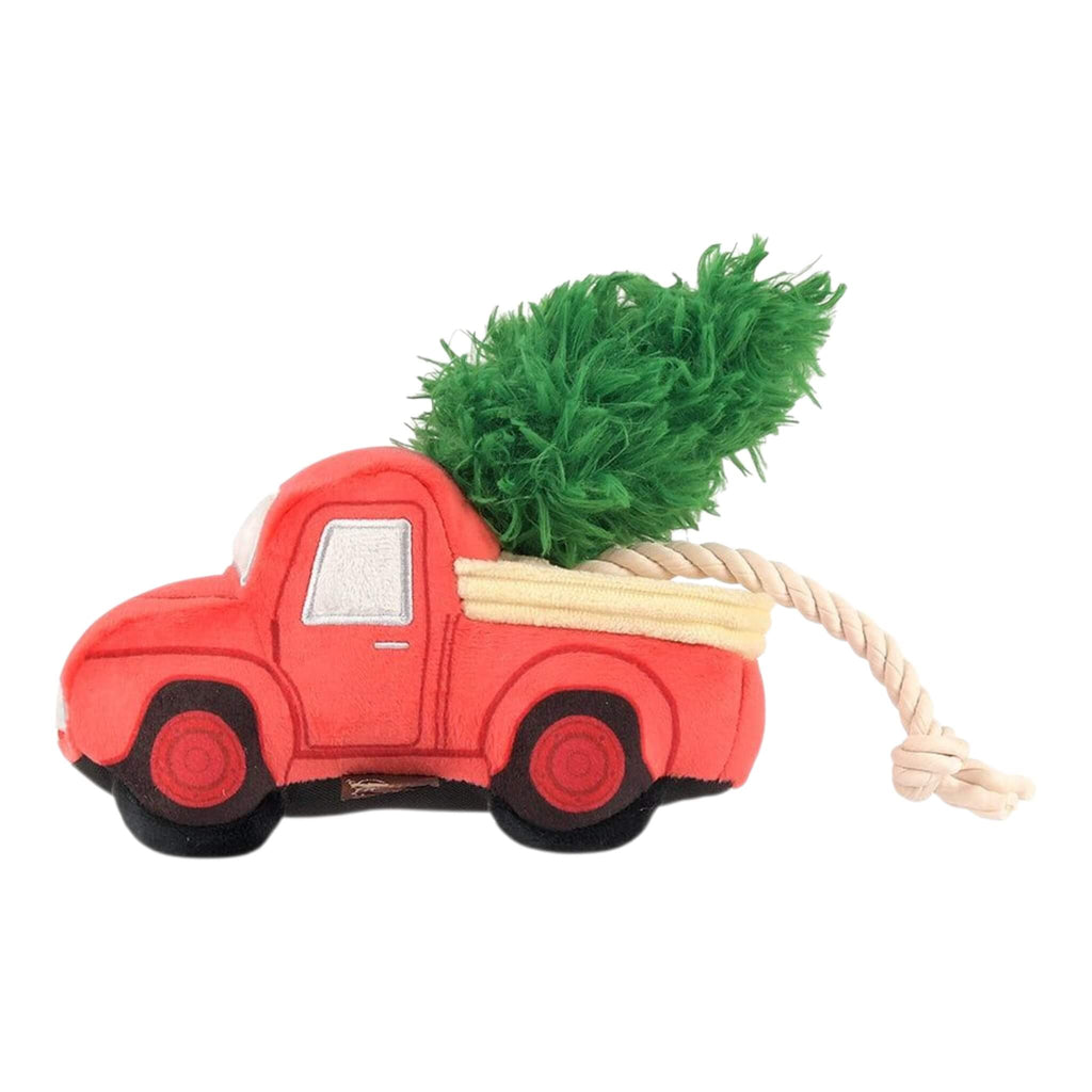 Plush red truck dog toy with a green tree on a white background