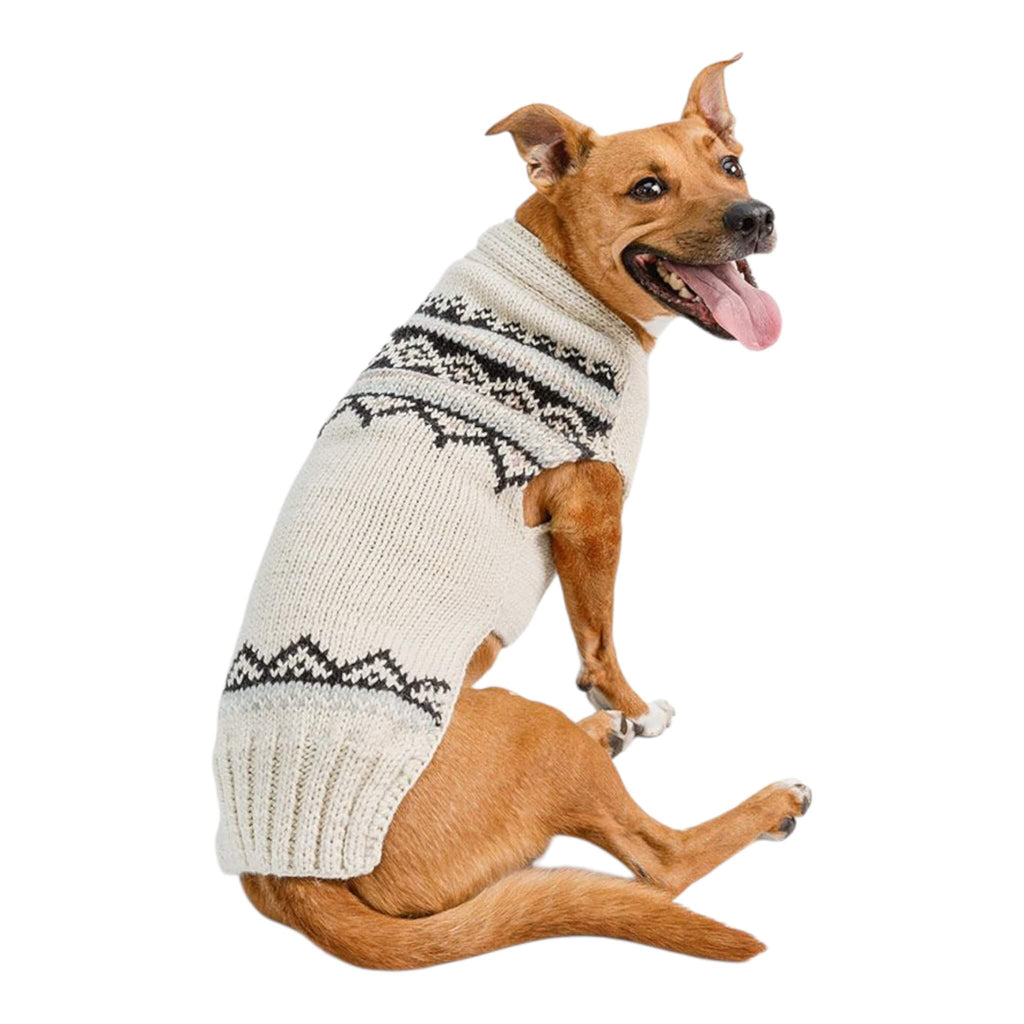 Dog wearing a Fair Isle cream knitted sweater with black patterns on a white background