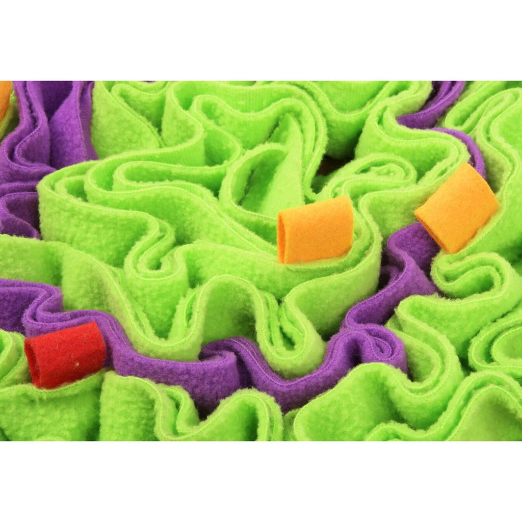 Close-up of a dog snuffle mat with green and purple textured fabric on a white background