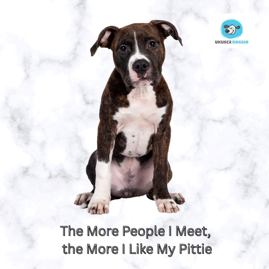 Pit bull puppy sitting on a white background with text 'The More People I Meet, the More I Like My Pittie' and a logo in the corner.