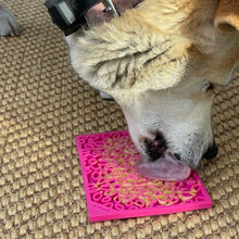 Load image into Gallery viewer, Dog licks up peanut butter from his Flower Power Emat Enrichment Licking Mat

